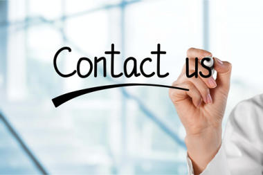 Woman writing contact us on a clear dry erase glass board